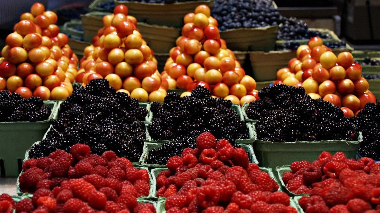 Puesto de frutas con montones de frutas rojas